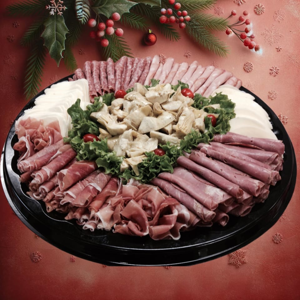 A festive holiday platter from Leona's Pizzeria with various meats, cheeses, artichokes, and cherry tomatoes.