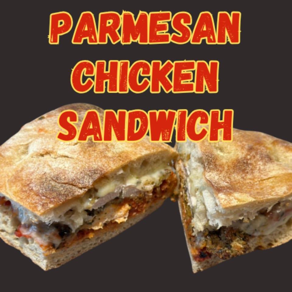 Leona's Pizzeria Parmesan Chicken Sandwich, cut in half, revealing melted cheese and chicken.