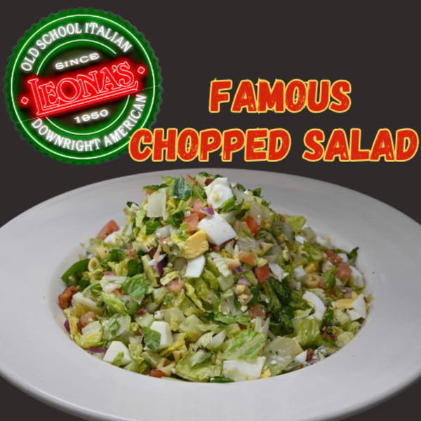Leona's Pizzeria's famous chopped salad, a vibrant mix of greens, eggs, and vegetables in a white bowl.