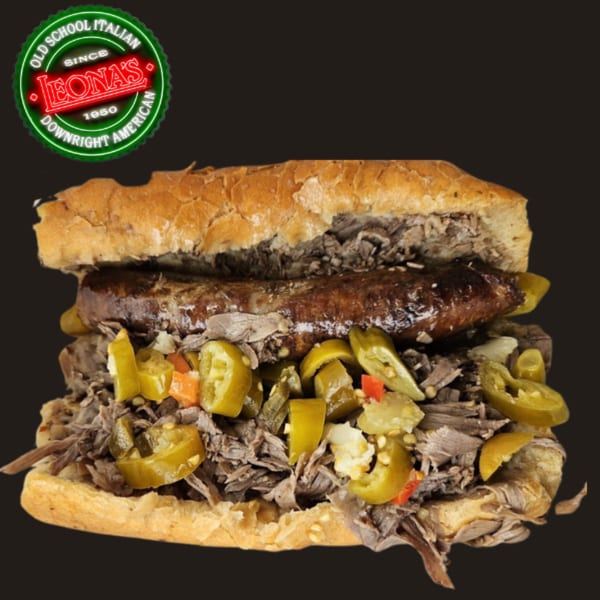 Leona's Pizzeria Italian beef sandwich with sausage and giardiniera, against a dark background.